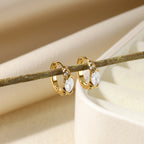 Elegant paired gold huggie hoop earrings with continuous clear zirconia and a central marquise-cut stone