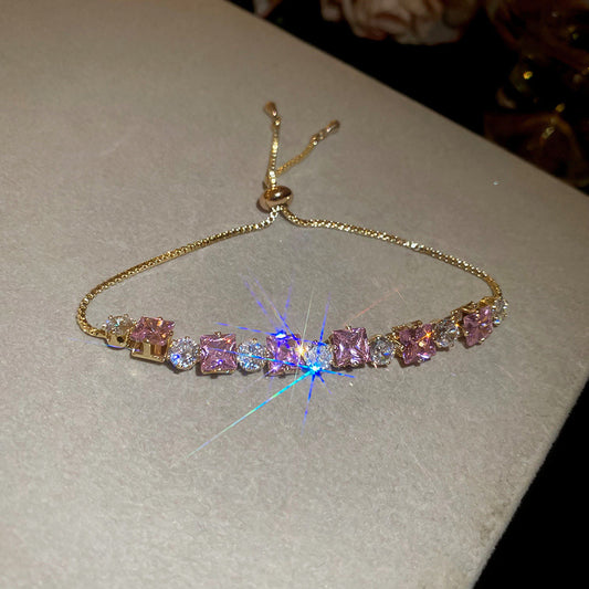 Sparkling gold tennis bracelet featuring multi-color and pink cubic zirconia in a continuous link design