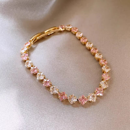 Classic gold tennis bracelet featuring a continuous line of sparkling pink cubic zirconia stones