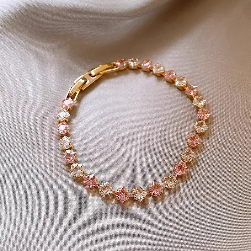 Classic gold tennis bracelet featuring a continuous line of sparkling pink cubic zirconia stones