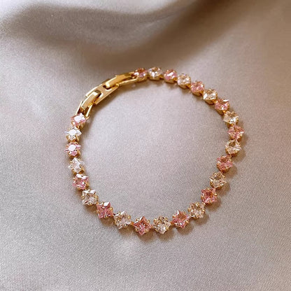 Classic gold tennis bracelet featuring a continuous line of sparkling pink cubic zirconia stones