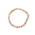 Classic gold tennis bracelet featuring a continuous line of sparkling pink cubic zirconia stones