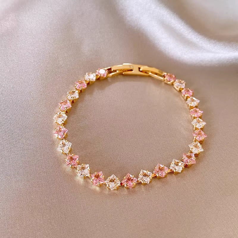 Classic gold tennis bracelet featuring a continuous line of sparkling pink cubic zirconia stones