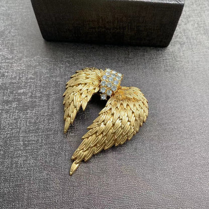 Elegant gold plated angel wing brooch featuring shimmering white cubic zirconia stones in a detailed feather design