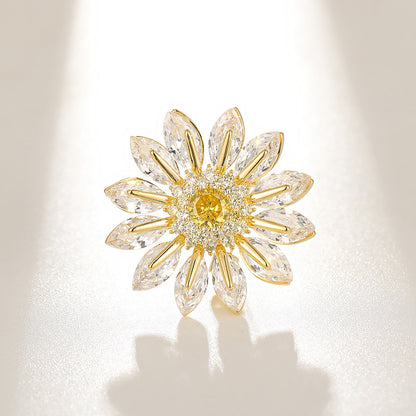 Charming gold plated daisy brooch featuring white cubic zirconia petals and a bright yellow stamen center