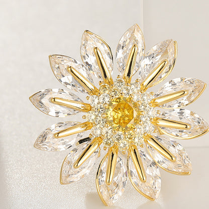 Charming gold plated daisy brooch featuring white cubic zirconia petals and a bright yellow stamen center