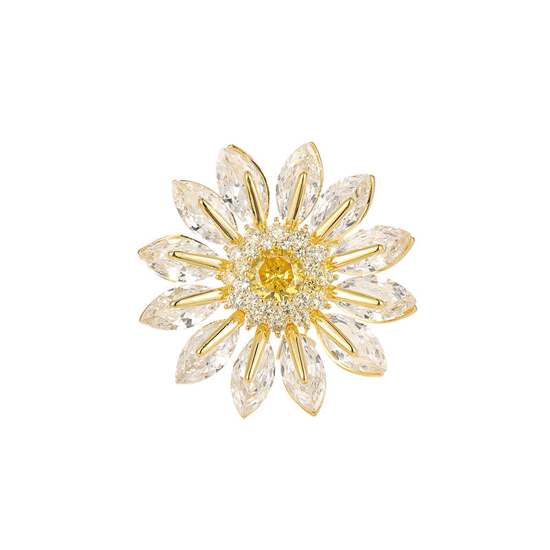 Charming gold plated daisy brooch featuring white cubic zirconia petals and a bright yellow stamen center