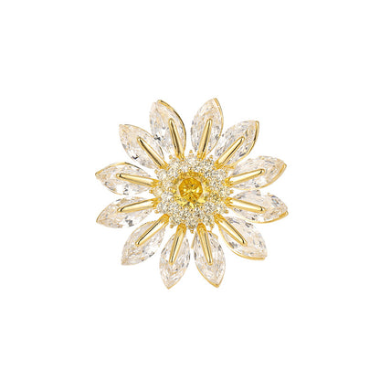 Charming gold plated daisy brooch featuring white cubic zirconia petals and a bright yellow stamen center