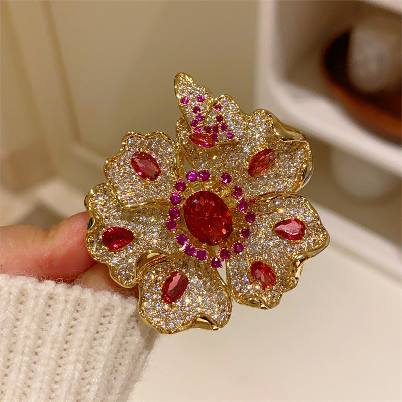 Elegant gold plated double-petal flower brooch featuring sparkling white cubic zirconia in a blooming design