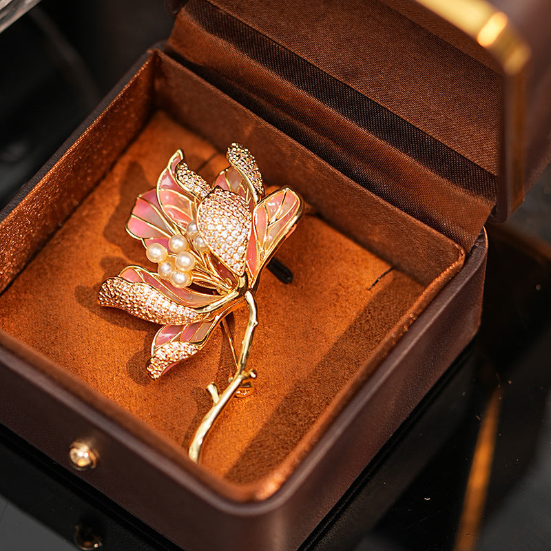 Elegant gold kapok flower brooch with pink and white zirconia petals and a central pearl accent
