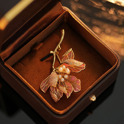 Elegant gold kapok flower brooch with pink and white zirconia petals and a central pearl accent