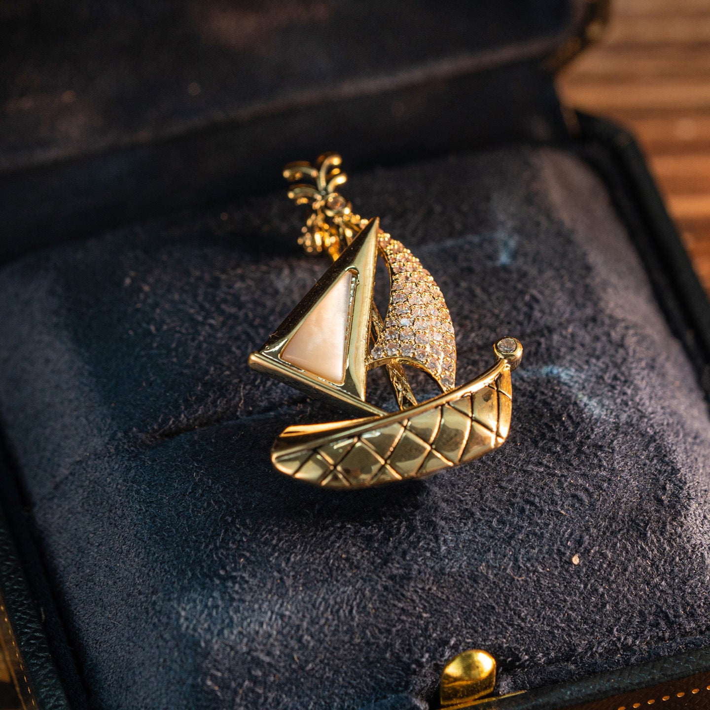 Elegant gold plated sailboat brooch featuring shimmering white cubic zirconia sails in a nautical-inspired design