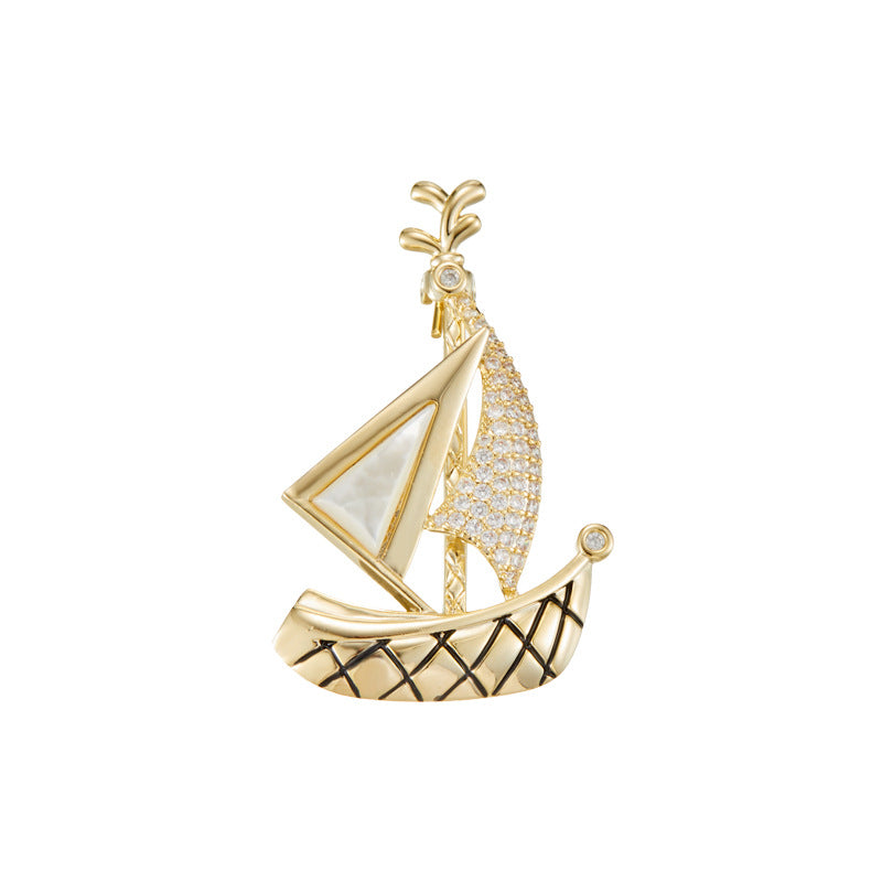 Elegant gold plated sailboat brooch featuring shimmering white cubic zirconia sails in a nautical-inspired design
