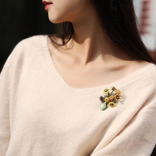Vintage-style gold-plated sunflower brooch featuring vibrant yellow enamel petals and a textured floral design
