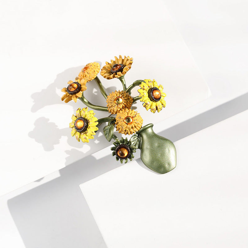 Vintage-style gold-plated sunflower brooch featuring vibrant yellow enamel petals and a textured floral design