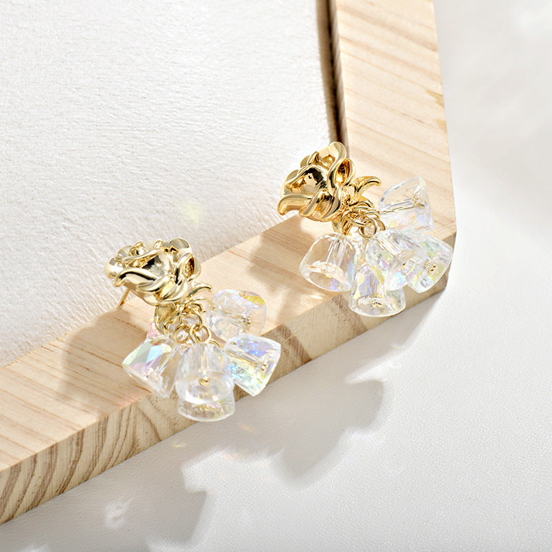 Gold dangle earrings featuring a delicate rose flower top and an intricate hollow bell charm for a vintage look