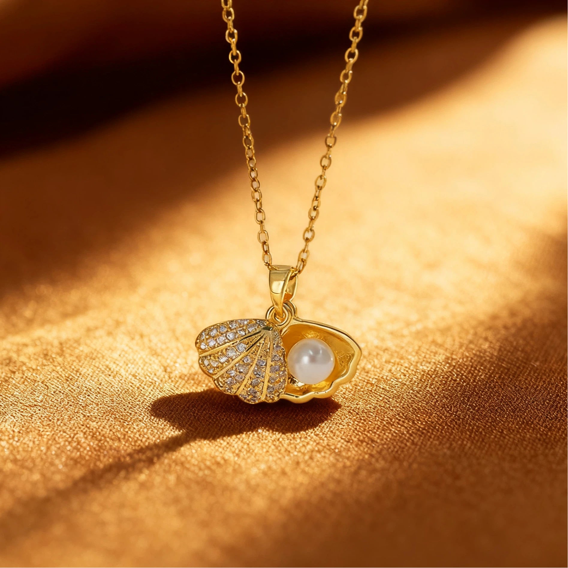 Elegant gold necklace featuring a shell-shaped pendant with a central pearl and shimmering zircon stones on the outer rim