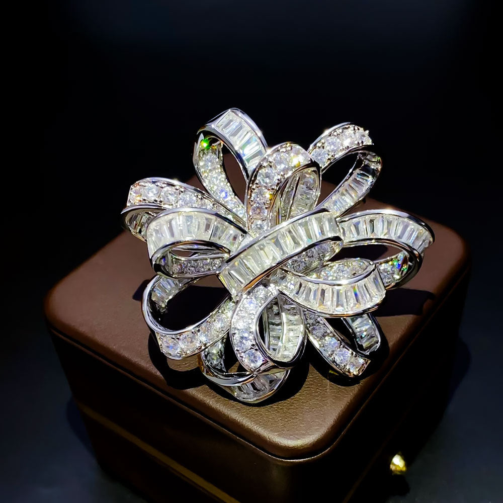 Dainty bowknot brooch with white cubic zirconia ribbon design, available in gold and silver plated finishes