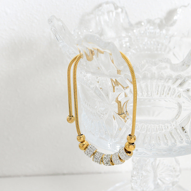 Chic cylindrical bead bracelet featuring a sparkling zirconia halo, available in gold and silver plated finishes