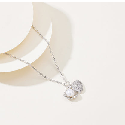 Elegant gold  silver necklace featuring a shell-shaped pendant with a central pearl and shimmering zircon stones on the outer rim