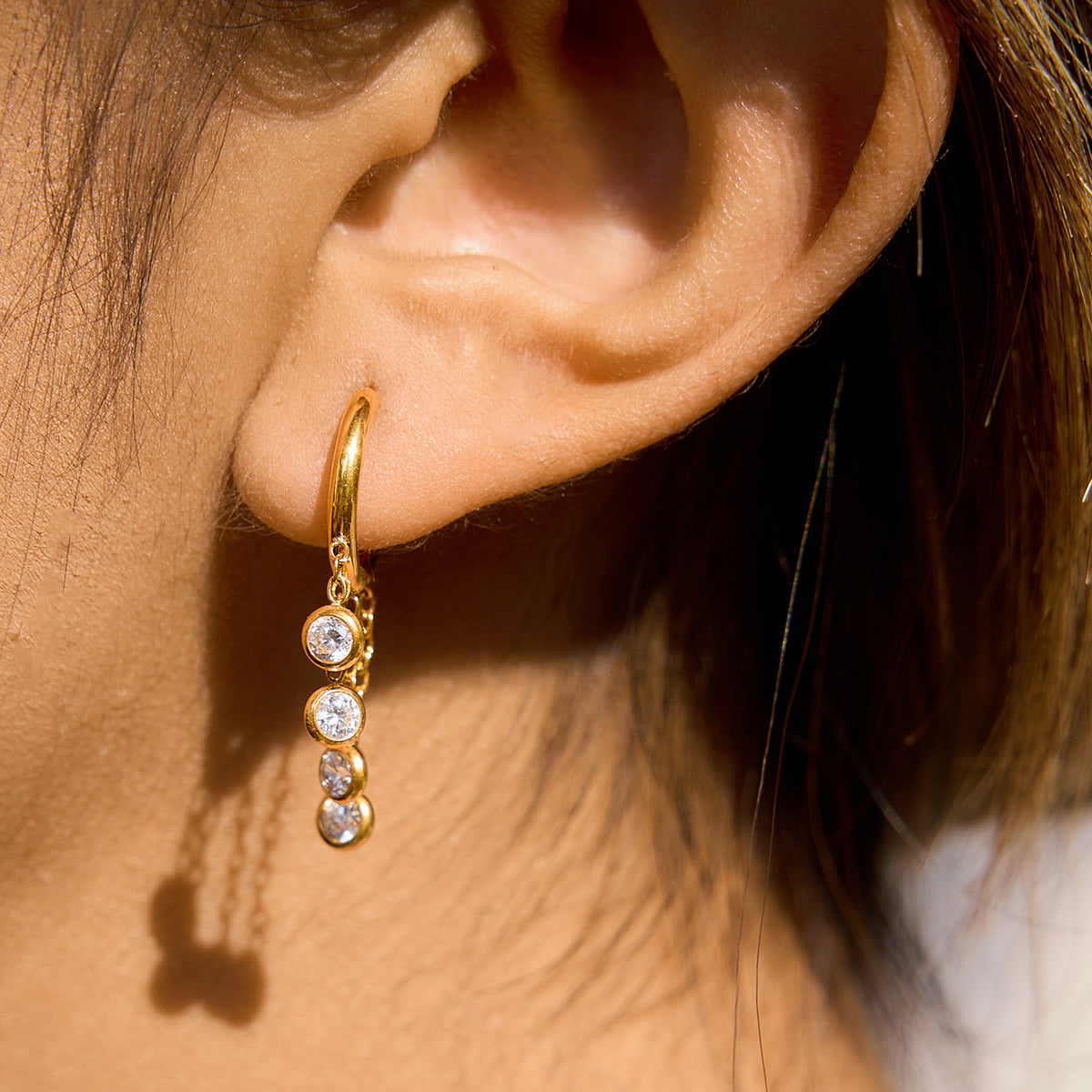 Gold stainless steel chunky hoop earrings featuring three rows of sparkling clear zirconia stones