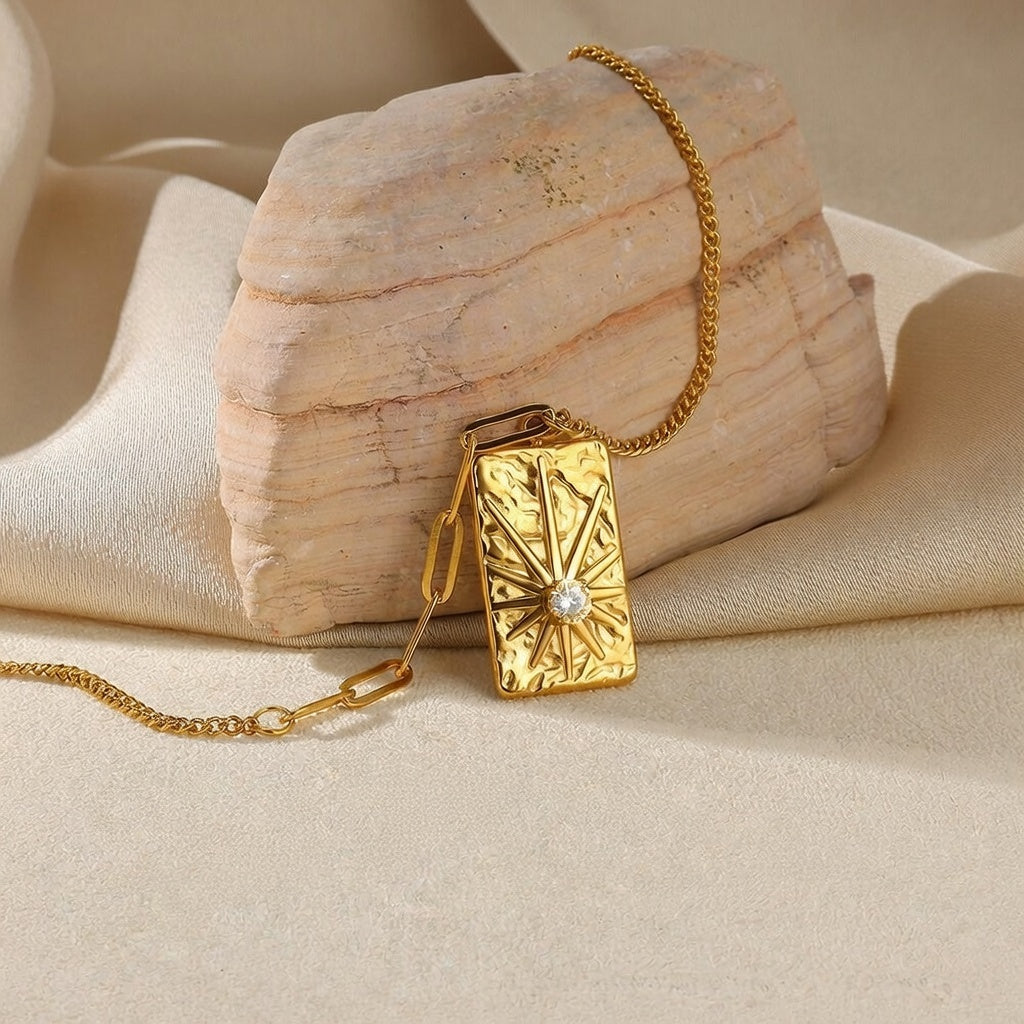 Elegant gold sunburst pendant necklace featuring a brilliant circular zircon centerpiece in a radiant celestial starburst design