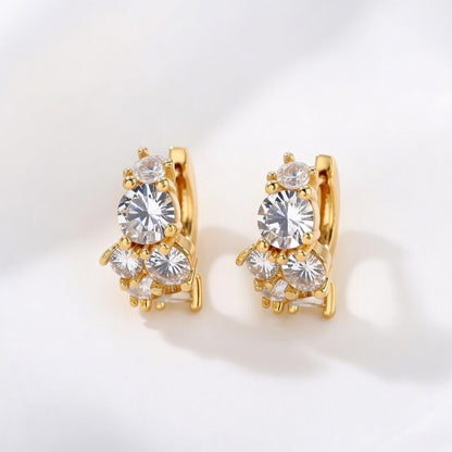 Gold huggie hoop earrings featuring a continuous row of sparkling clear zirconia stones in a polished pave