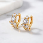 Gold huggie hoop earrings featuring a continuous row of sparkling clear zirconia stones in a polished pave
