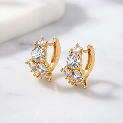 Gold huggie hoop earrings featuring a continuous row of sparkling clear zirconia stones in a polished pave