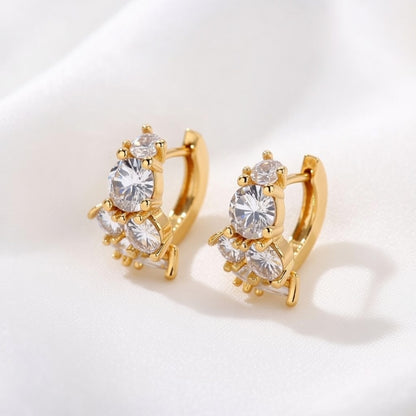 Gold huggie hoop earrings featuring a continuous row of sparkling clear zirconia stones in a polished pave