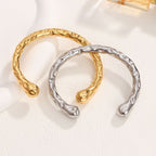 Organic hammered texture open cuff bangle in waterproof 18k gold plated stainless steel jewelry.