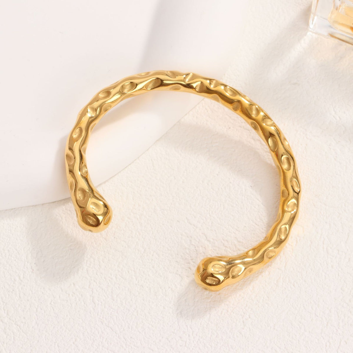 Organic hammered texture open cuff bangle in waterproof 18k gold plated stainless steel jewelry.