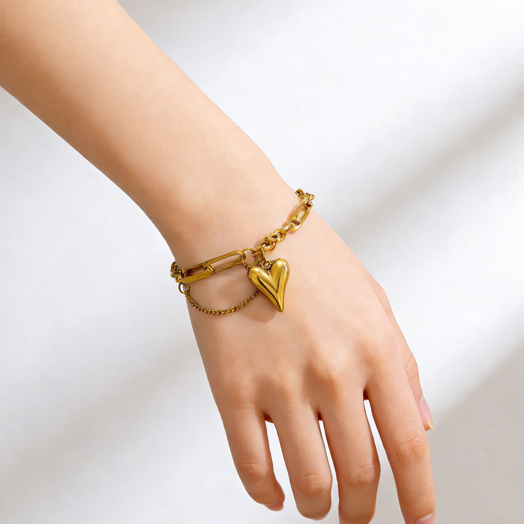 Puffy heart charm and paperclip link chain stainless steel jewelry bracelet in waterproof 18k gold plated finish.