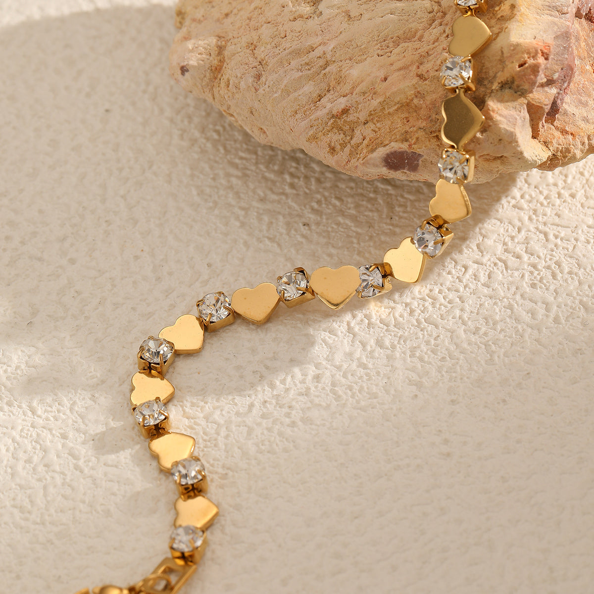 Polished gold heart and round cubic zirconia alternating tennis bracelet in 18k gold plated jewelry.