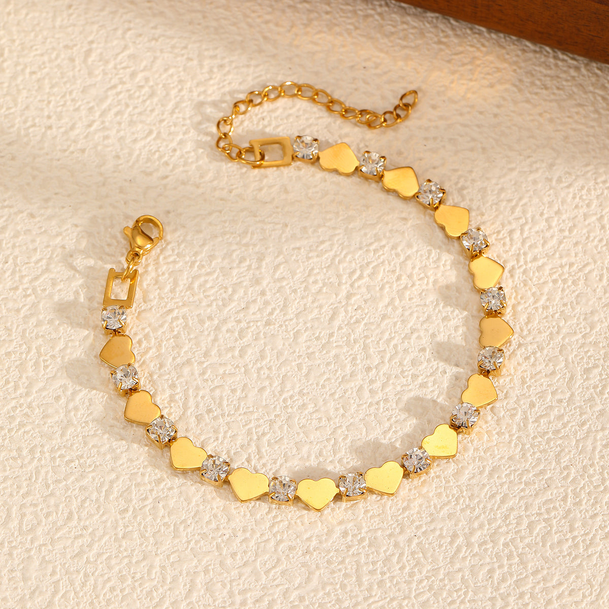 Polished gold heart and round cubic zirconia alternating tennis bracelet in 18k gold plated jewelry.