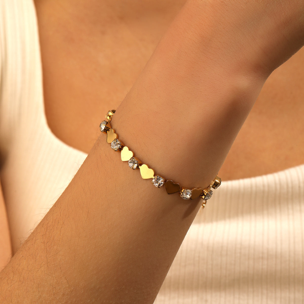 Polished gold heart and round cubic zirconia alternating tennis bracelet in 18k gold plated jewelry.