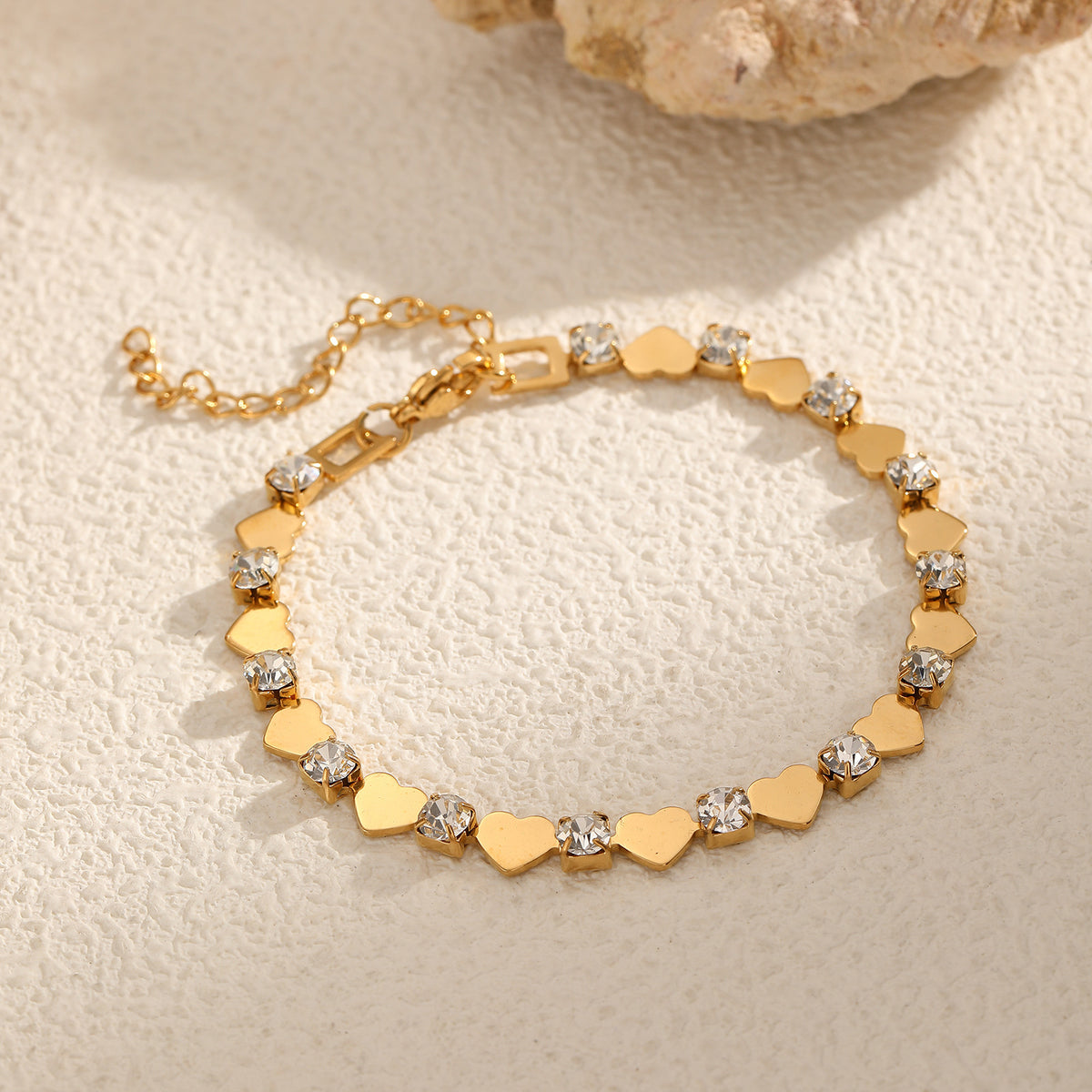 Polished gold heart and round cubic zirconia alternating tennis bracelet in 18k gold plated jewelry.