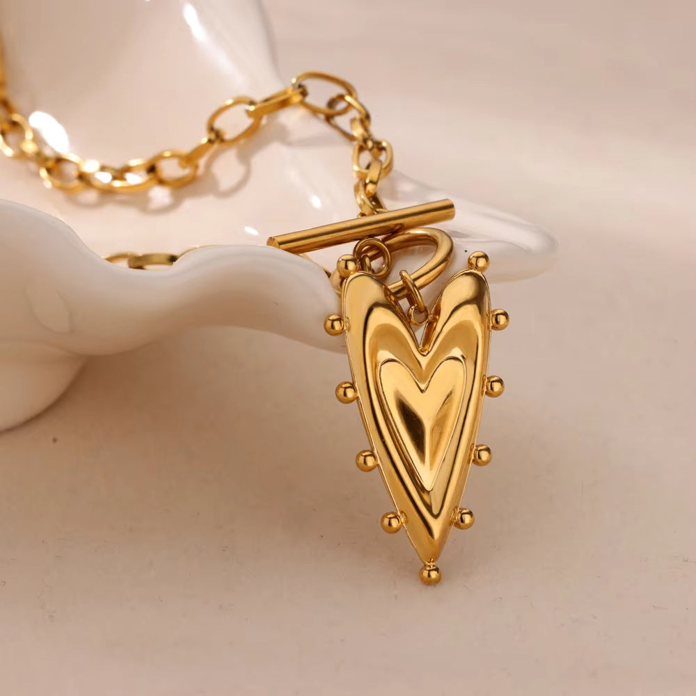 Minimalist gold heart pendant necklace featuring a sleek solid heart design on a delicate chain for everyday elegance
