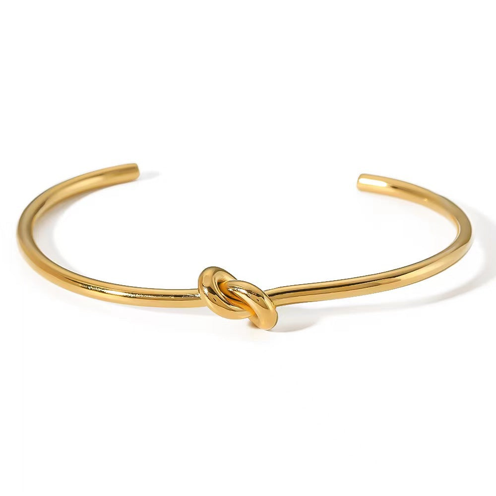 Minimalist knotted cuff bangle in 18k gold plated stainless steel jewelry.