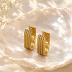Minimalist vertical striped U-shaped gold huggie hoop earrings with modern ribbed texture