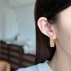 Minimalist vertical striped U-shaped gold huggie hoop earrings with modern ribbed texture