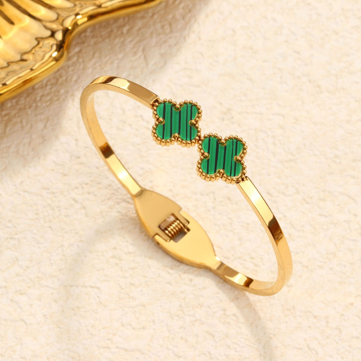 Double four-leaf clover inlay hinged cuff bangle in waterproof 18k gold plated titanium steel jewelry.