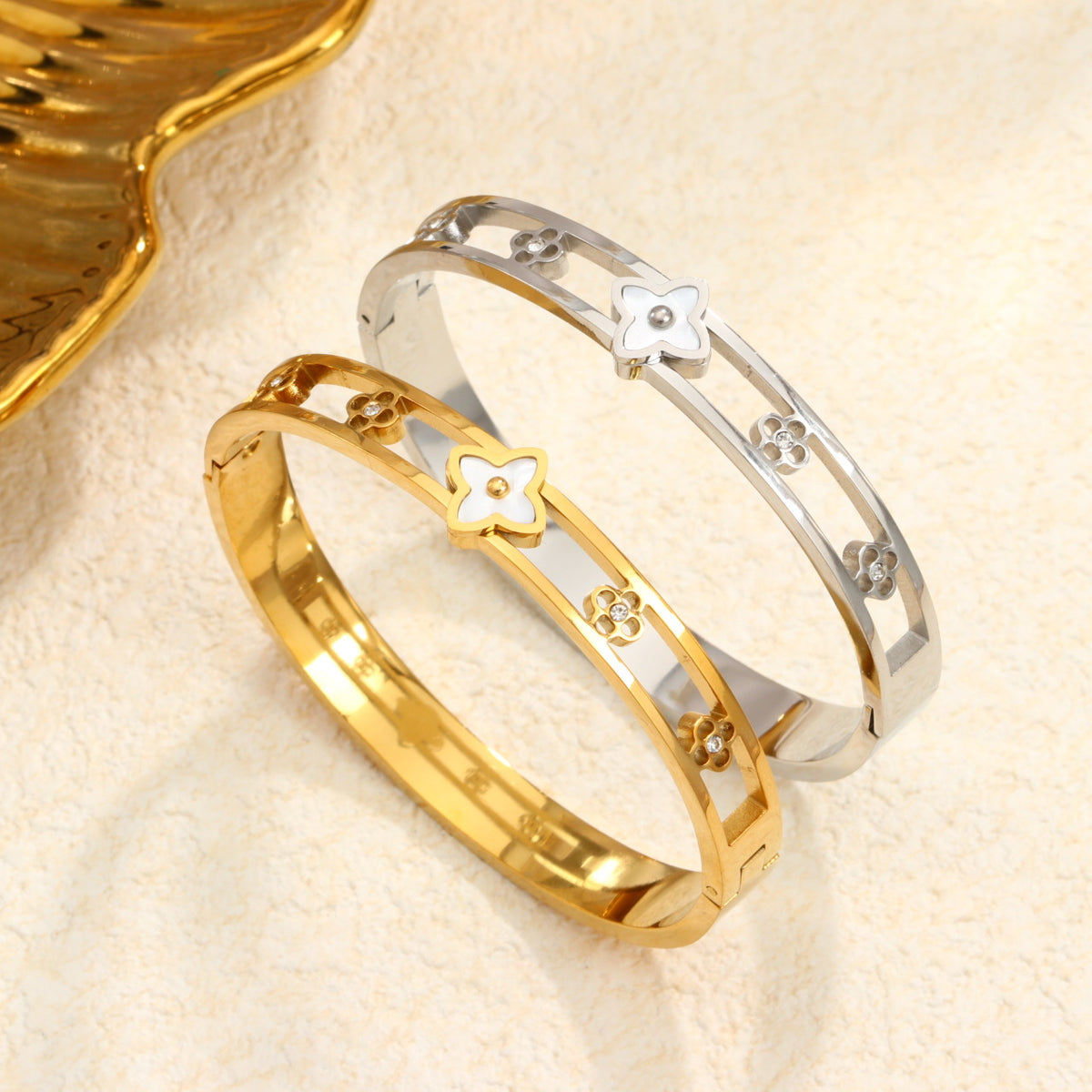 Mother of pearl monogram flower center motif and cut-out floral stations stainless steel jewelry bangle in waterproof 18k gold plated finish.