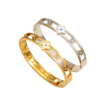Mother of pearl monogram flower center motif and cut-out floral stations stainless steel jewelry bangle in waterproof 18k gold plated finish.