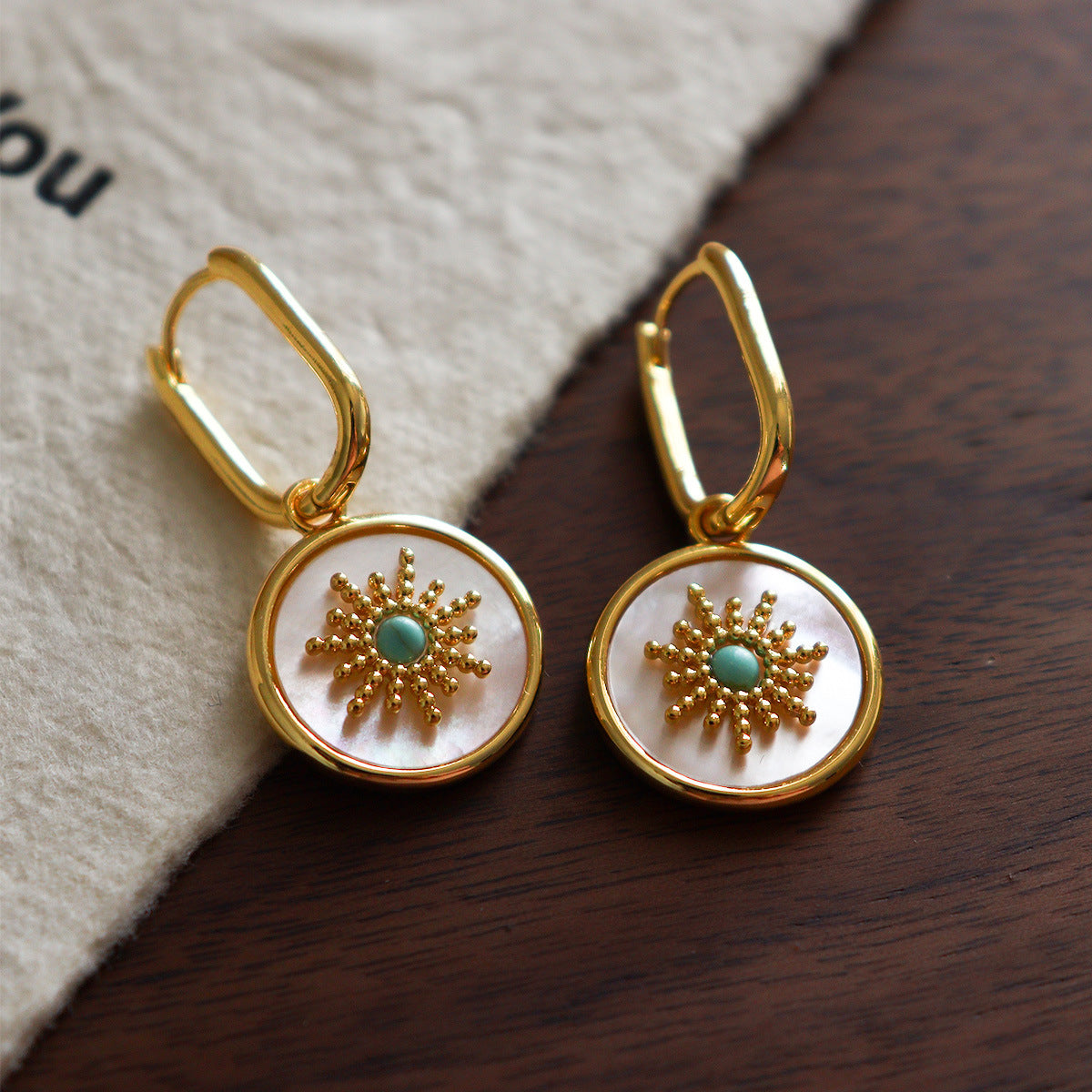 Mother of pearl round disc drop Stainless steel jewelry earrings with gold starburst motif inlaid with turquoise natural stone center