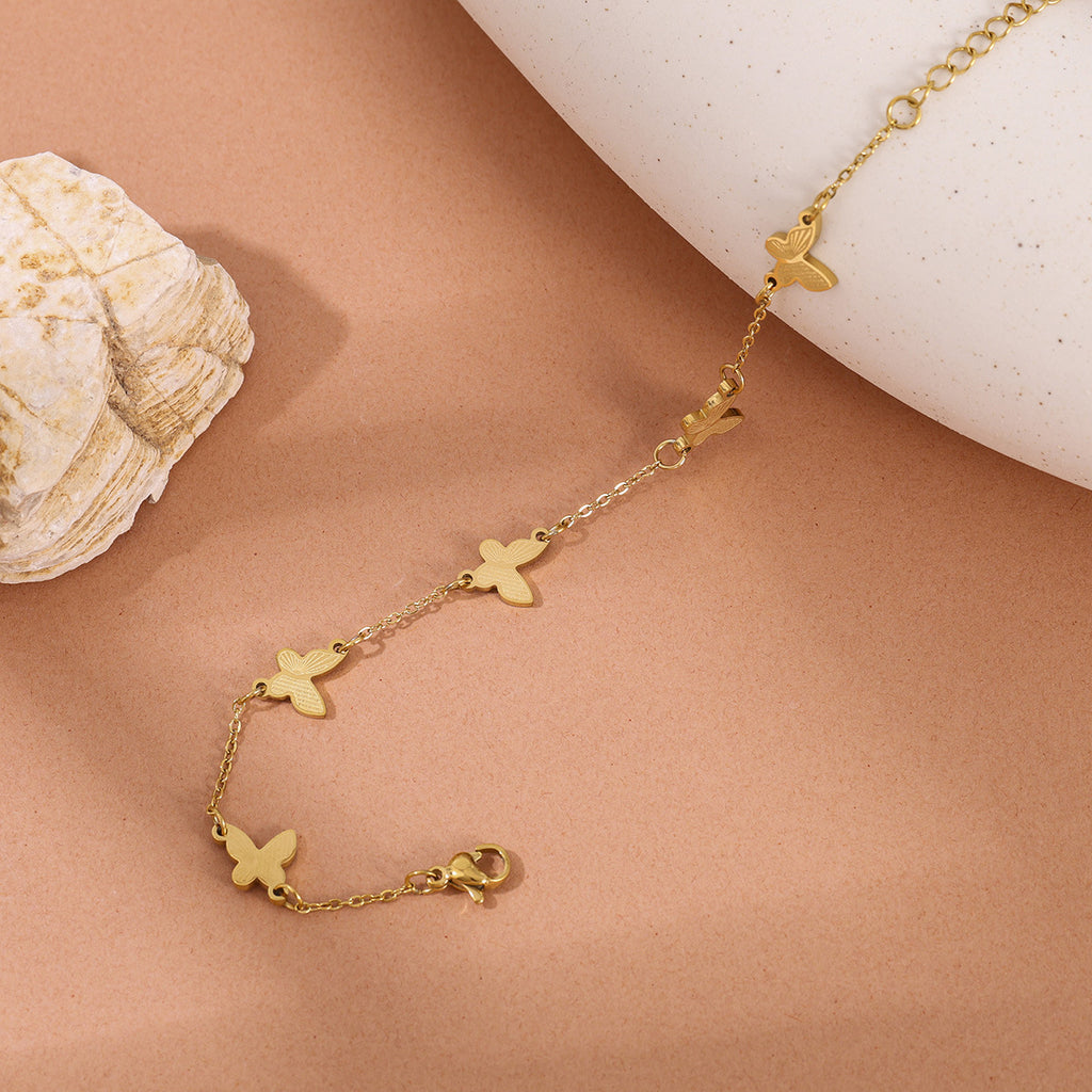 Textured butterfly charm stations fine link chain stainless steel jewelry bracelet in waterproof 18k gold plated finish.