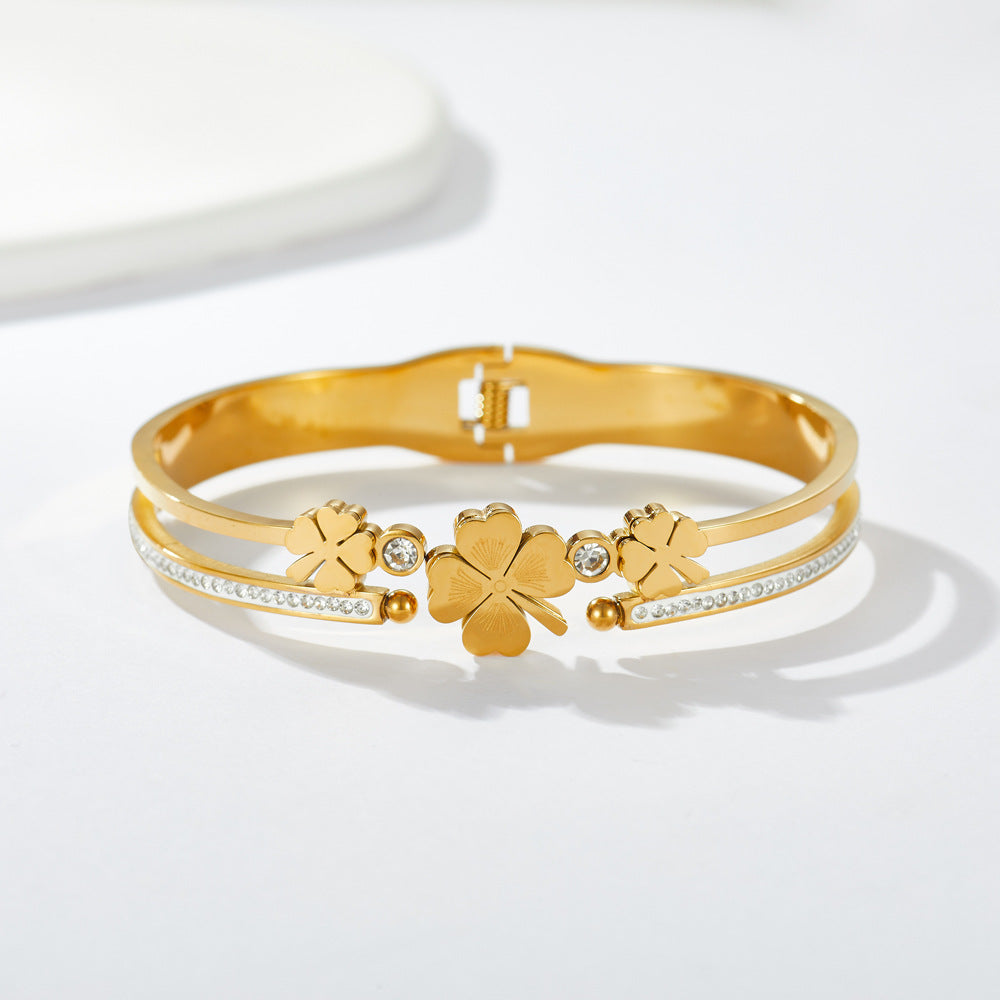 Multi four-leaf clover station and pave cubic zirconia accent stainless steel jewelry bangle in waterproof 18k gold plated finish.