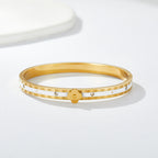 Multi four-leaf clover station and pave cubic zirconia accent stainless steel jewelry bangle in waterproof 18k gold plated finish.