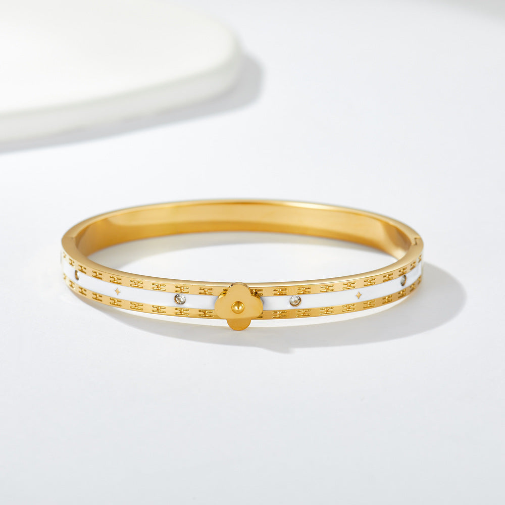 Multi four-leaf clover station and pave cubic zirconia accent stainless steel jewelry bangle in waterproof 18k gold plated finish.
