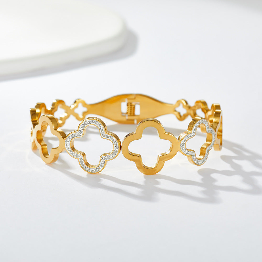 Multi four-leaf clover station and pave cubic zirconia accent stainless steel jewelry bangle in waterproof 18k gold plated finish.